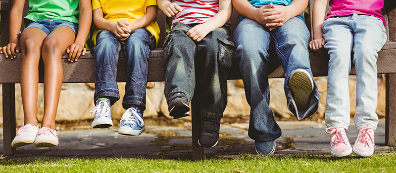 Close up view of classmates sitting on bench